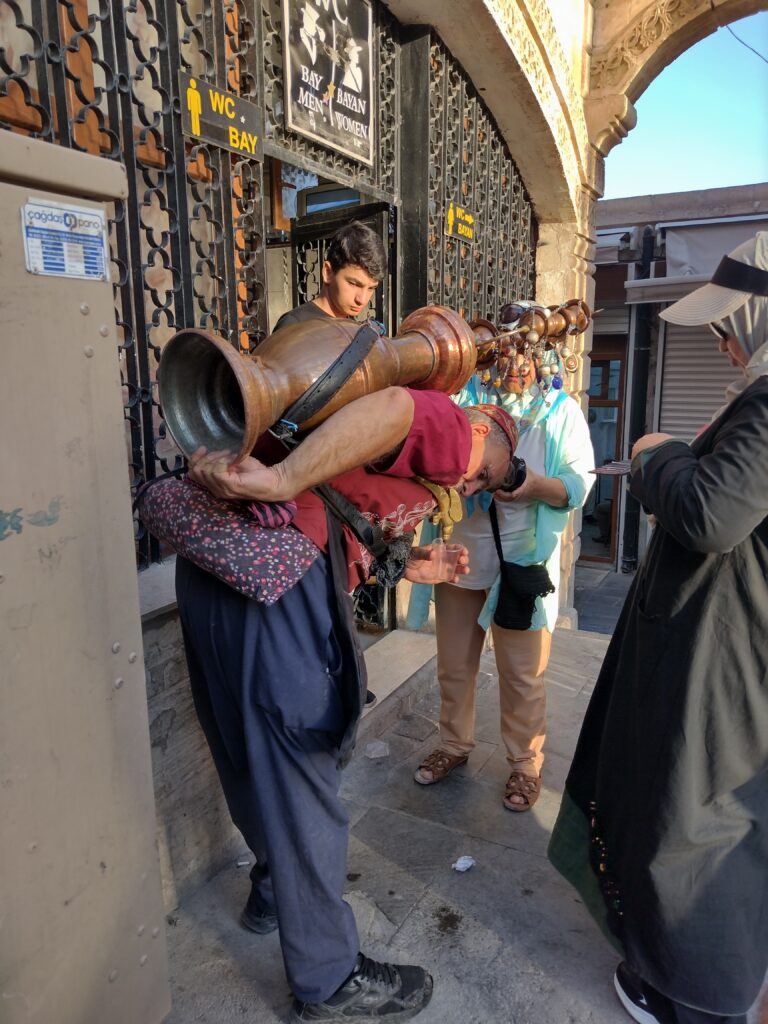 Napój z lukrecji lany prosto z przyczepionego na plecach dzbana 