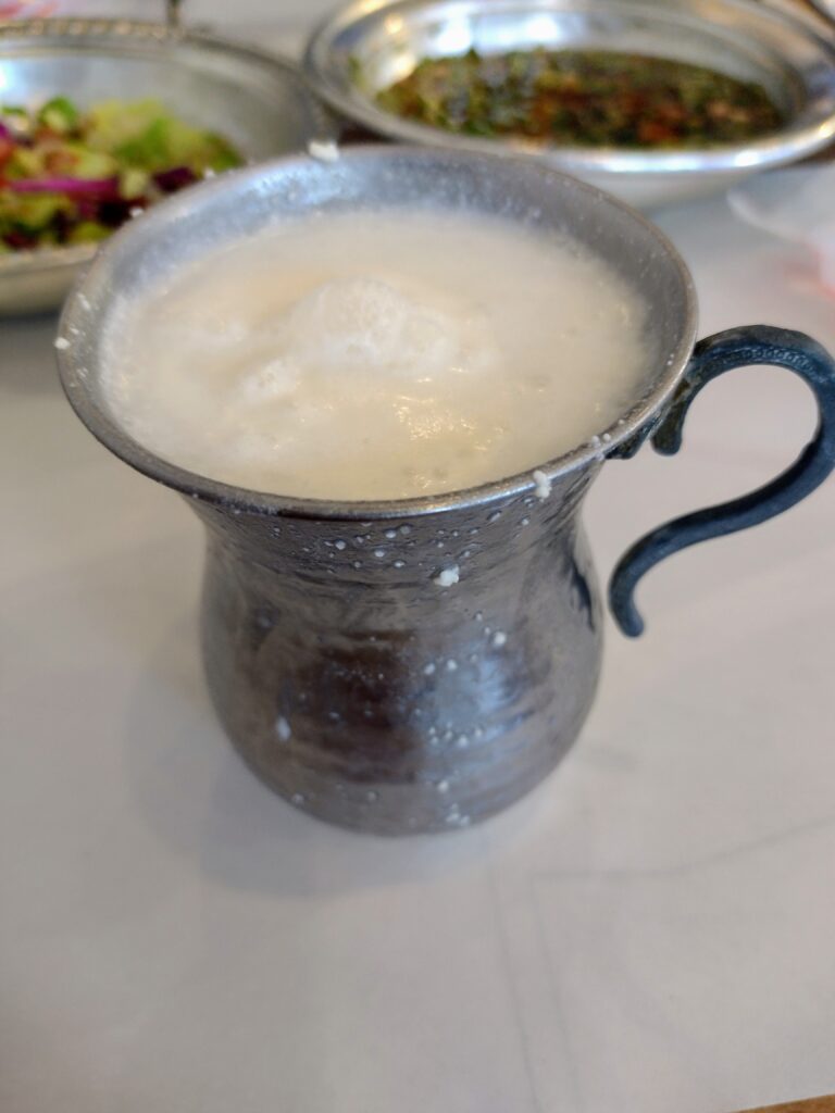 Spieniony ayran w metalowym kubku