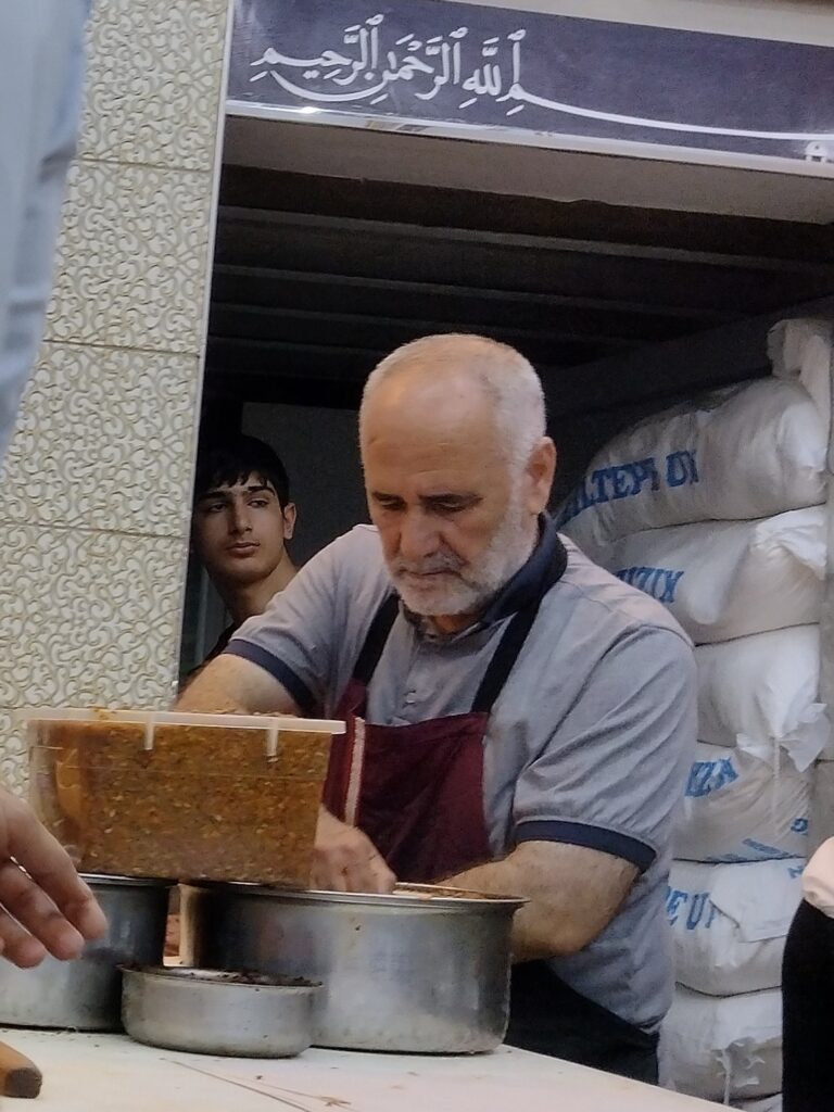 Przygotowywanie lahmacunów - nakładanie farszu mięsnego 